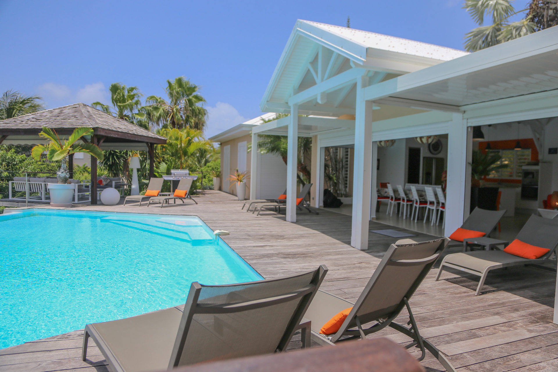 Piscine, transats orange et villa